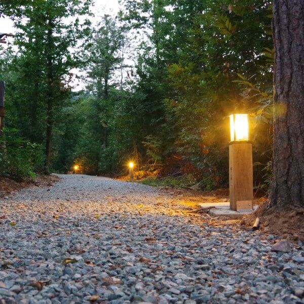 Holzwegbeleuchtung mit Aluminiumgussleuchte auf dem Campingplatz